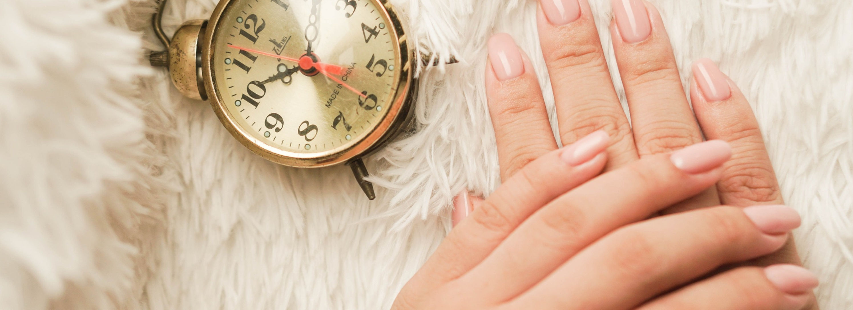 Pink manicure beside a vintage clock